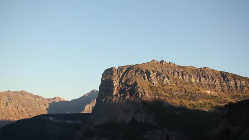 Shadows creep up a hillside on a sunny day