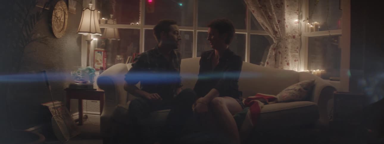 Man and woman sit on a couch and kiss