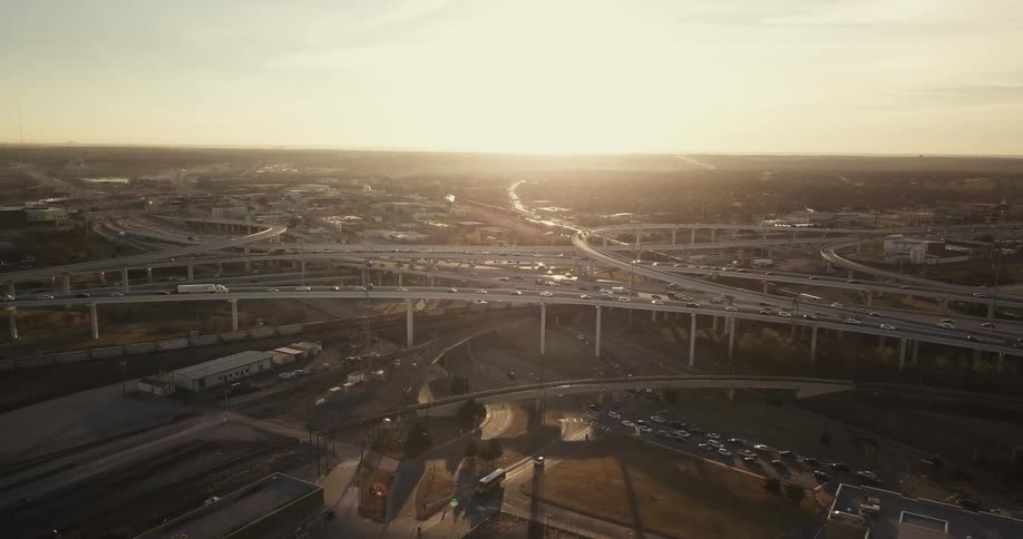 Cars traveling on criss crossing freeway over passes at sunset