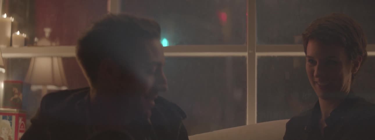 A man and woman kiss near the window