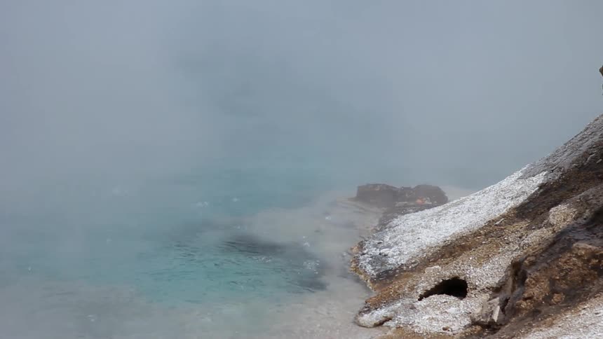 Steam rises from a shallow pool of water