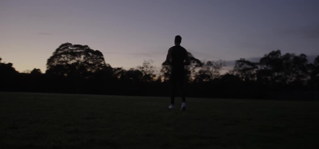 Silhouette of a man jogging backwards
