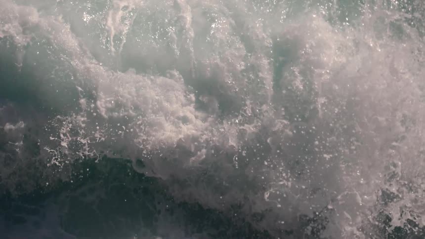 Ocean waves break and foam