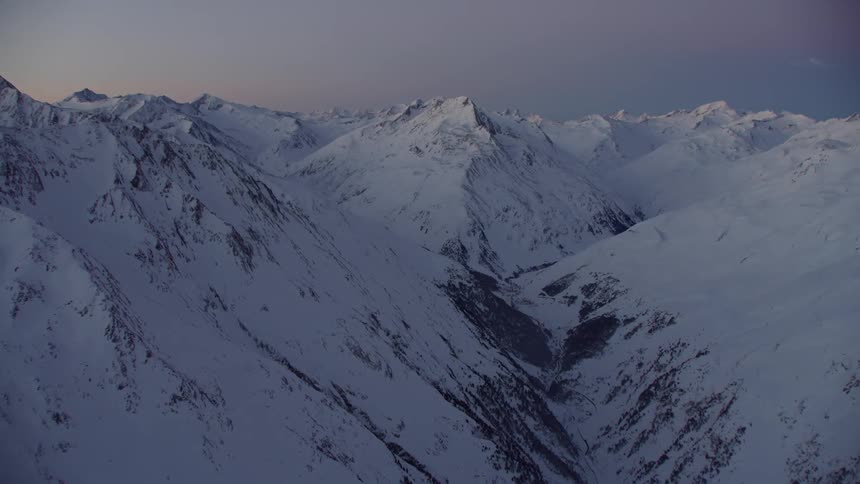 Snow mountains are shown at sunset