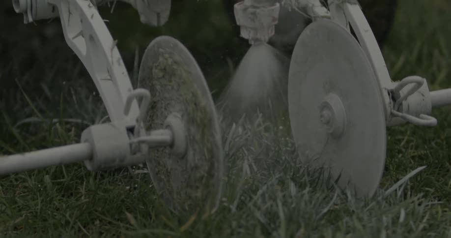 A farm vehicle irrigates the grass