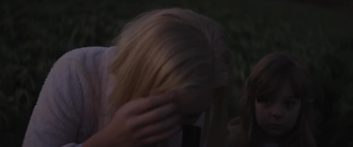A woman and child look through a telescope at dawn