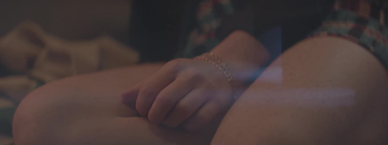 A woman lightly scratches her leg