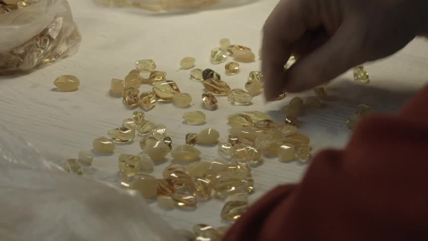 A woman sorts through gemstones