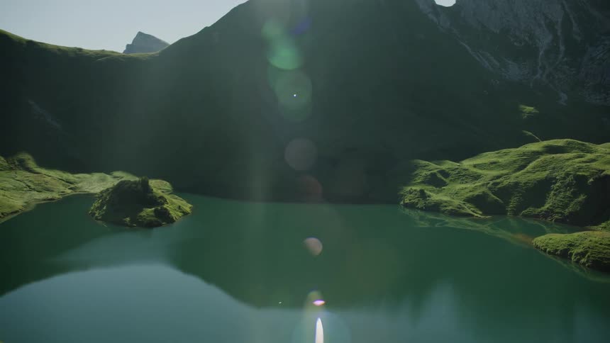 A still, green lake in a mountain valley