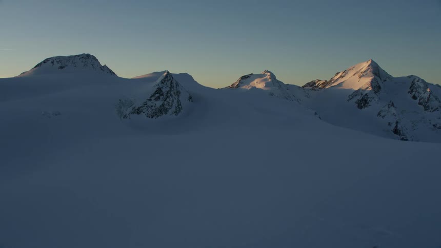Snow covers a rocky mountain ridge