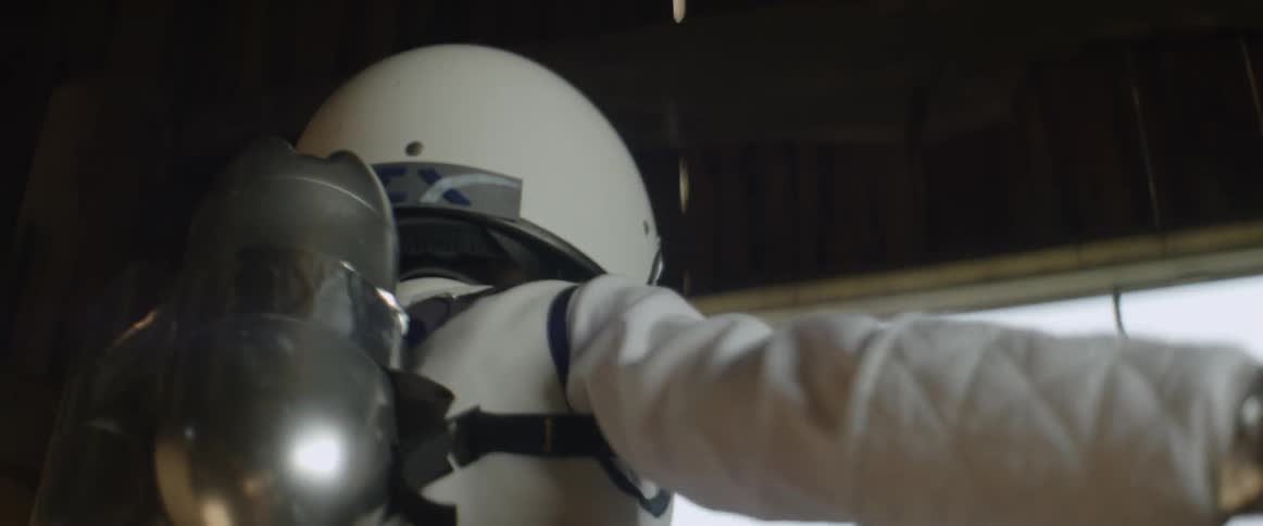 A person wearing a helmet and jetpack jumps towards a window