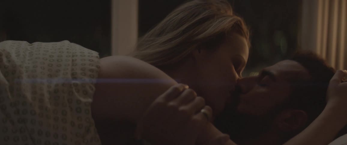 Couple lying down while caressing and kissing indoors