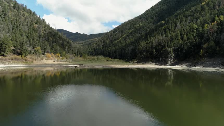 The lake leads up to a tree covered mountain