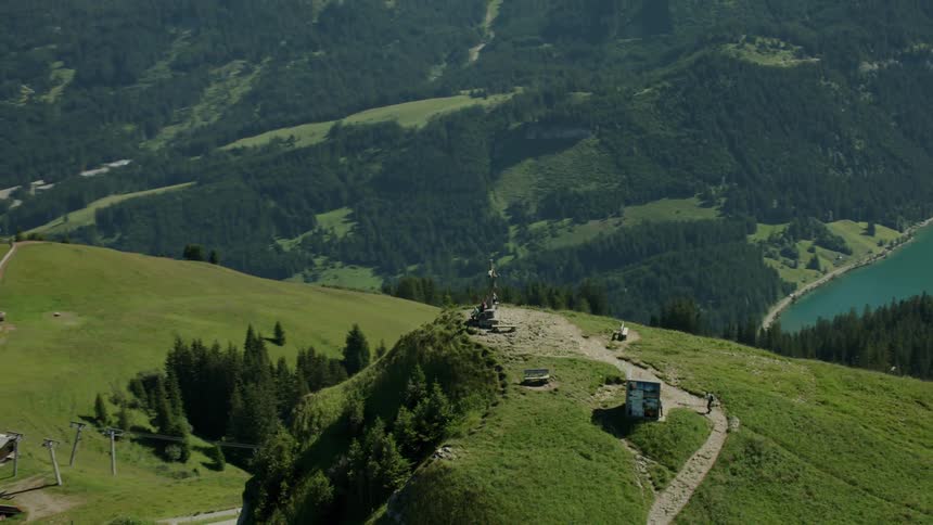 People are hiking and gathering around a cross on the mountain