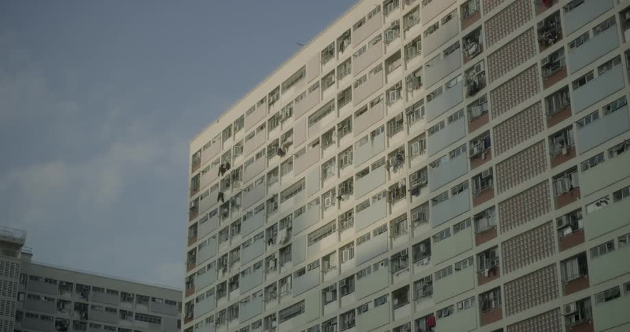 The side of a tall apartment building in city during the day