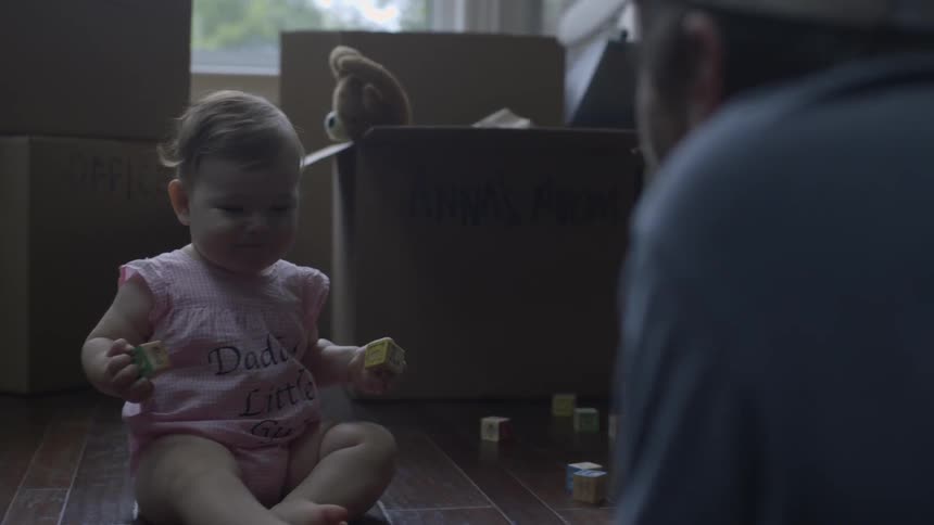 A man is playing with a baby on the floor