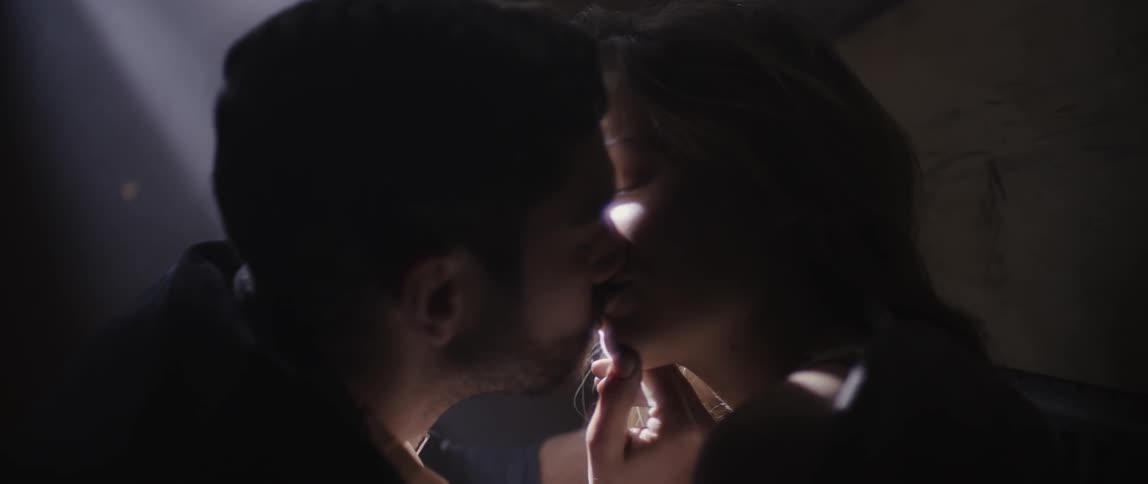 Man and woman kissing in dimly lit room