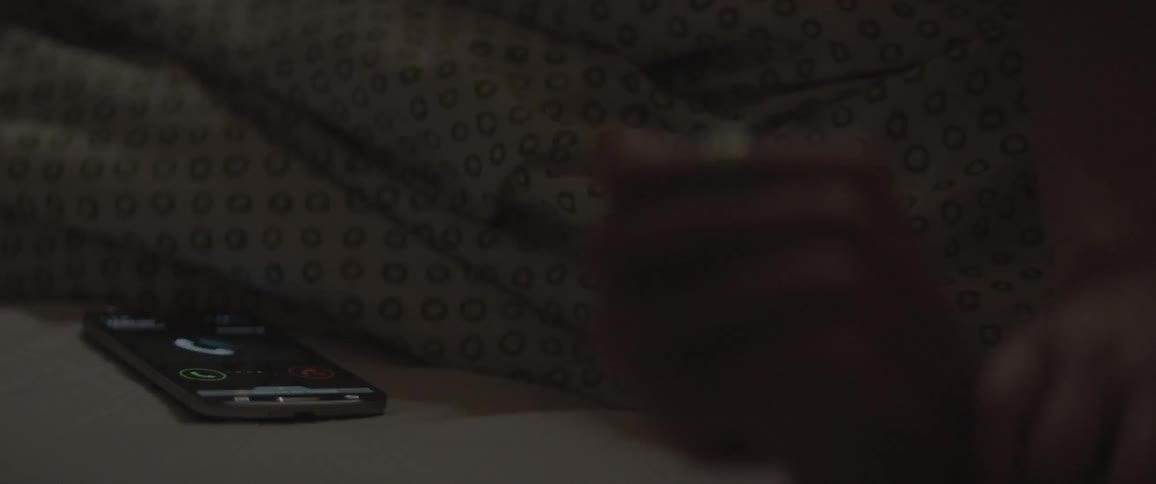 A cell phone rings next to two people fooling around in bed