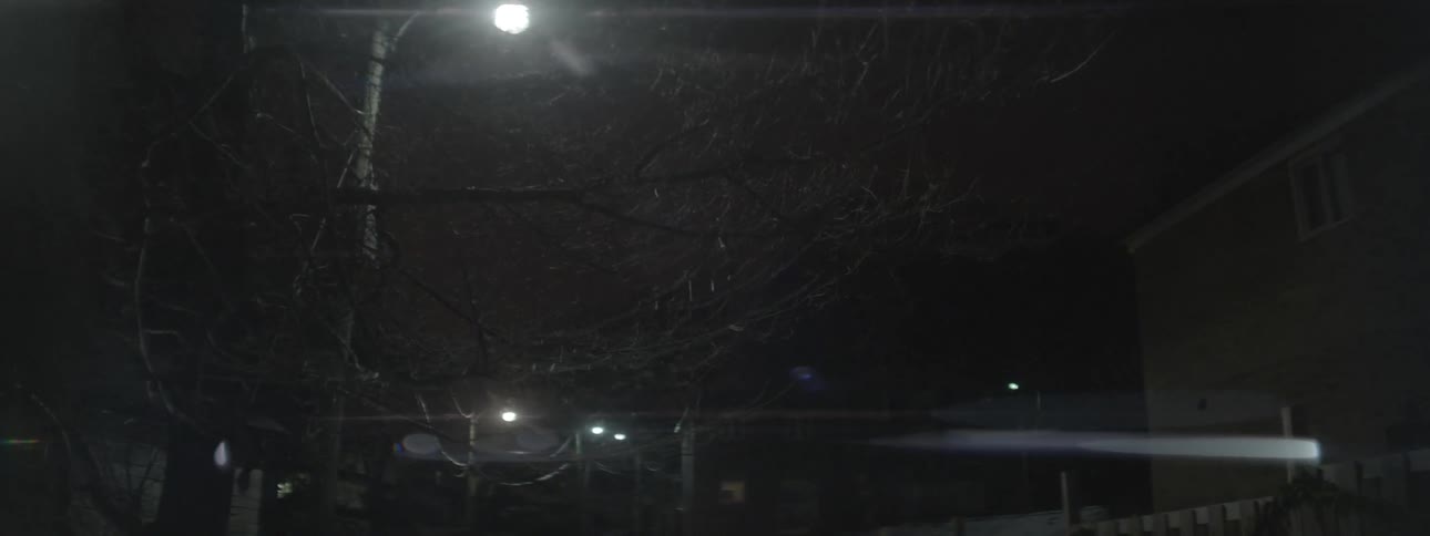 A vehicle is stopped in the road with its headlights on
