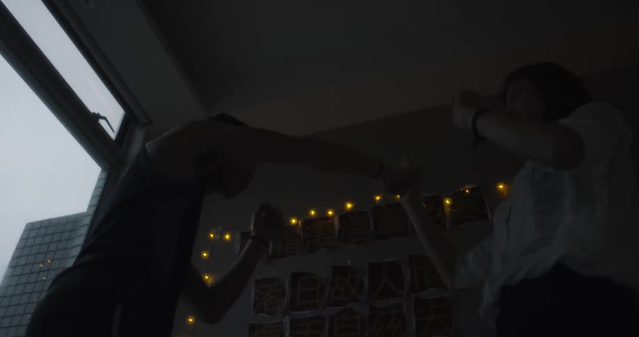 A man and woman play fight in an apartment