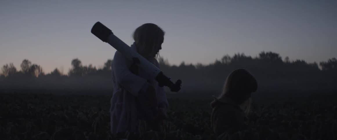 Woman carrying telescope walking with child outdoor after sunset