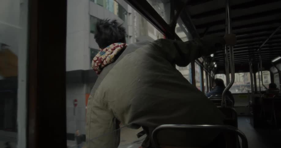 A man hangs out of a bus window