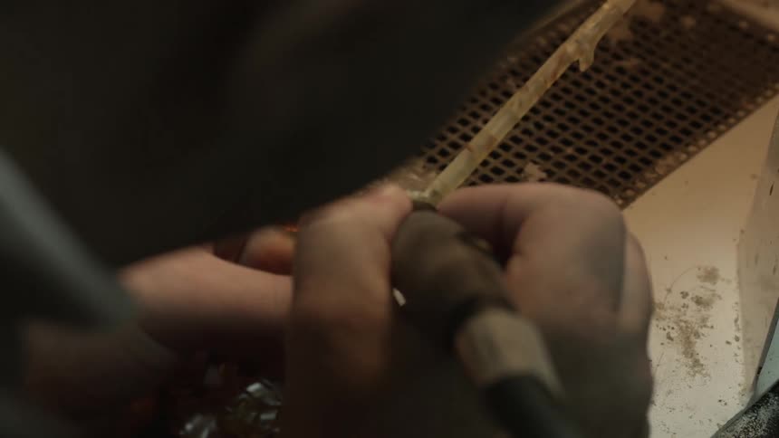 A man is carving a stone branch