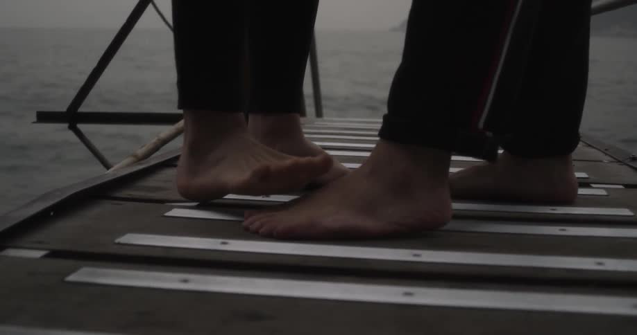 Two people playing on a dock barefoot