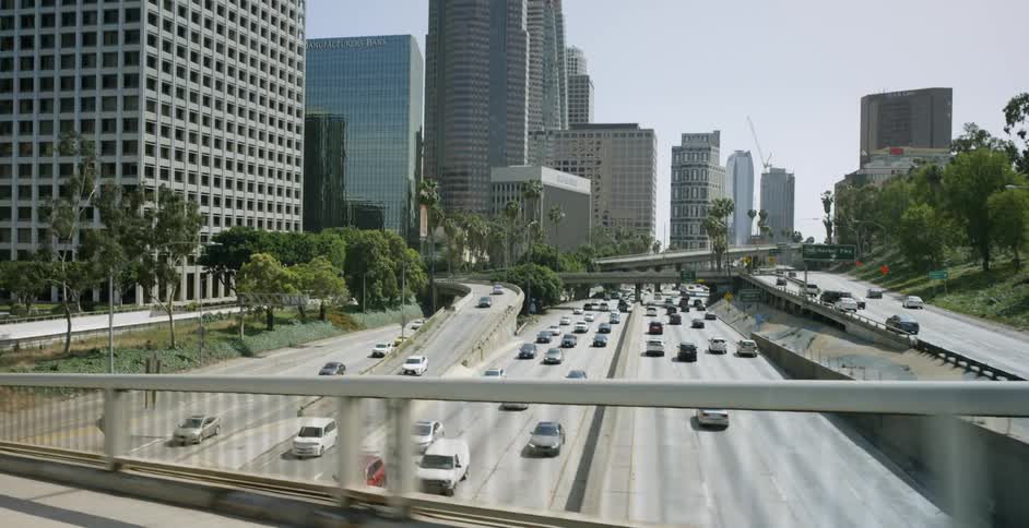 View of skyscrapers and a busy highway on a sunny day