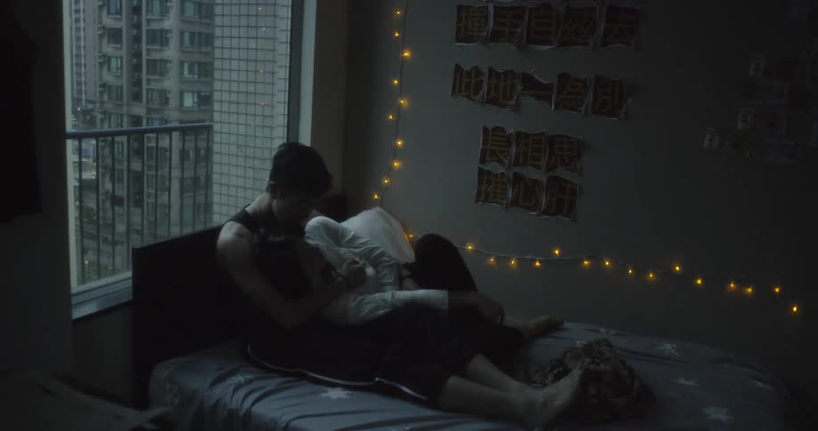 A man and woman hug on a bed