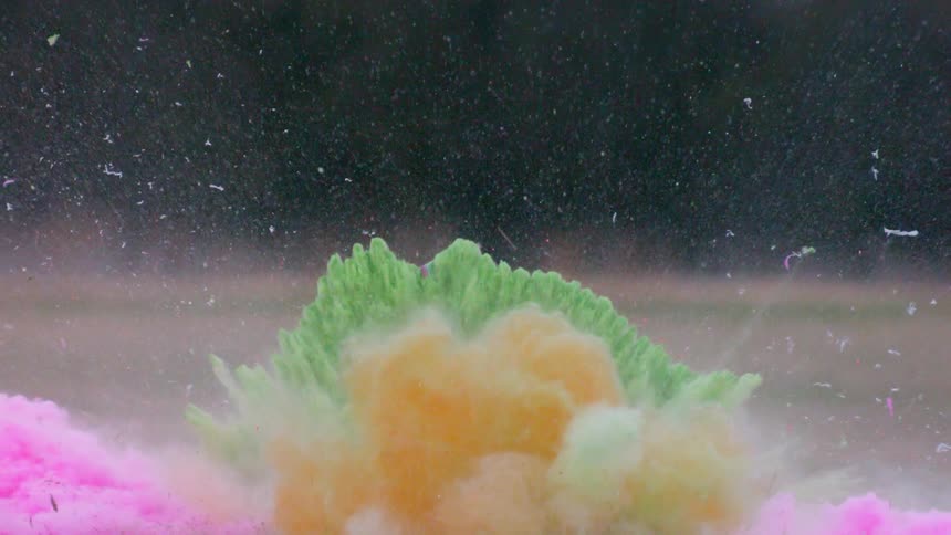 An explosion gives off colored dirt on the field