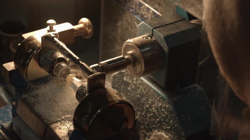 A person carving a small piece of wood