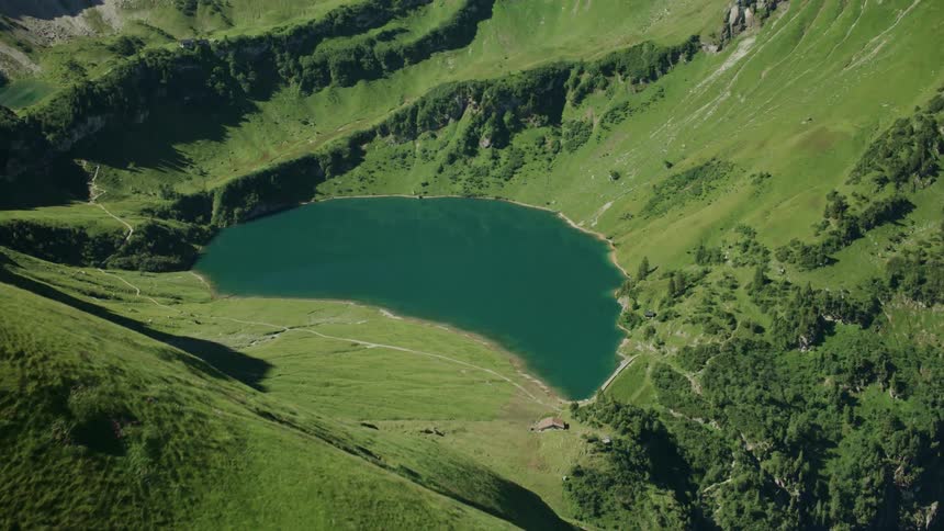Over the edge of the mountain is a small body of water below