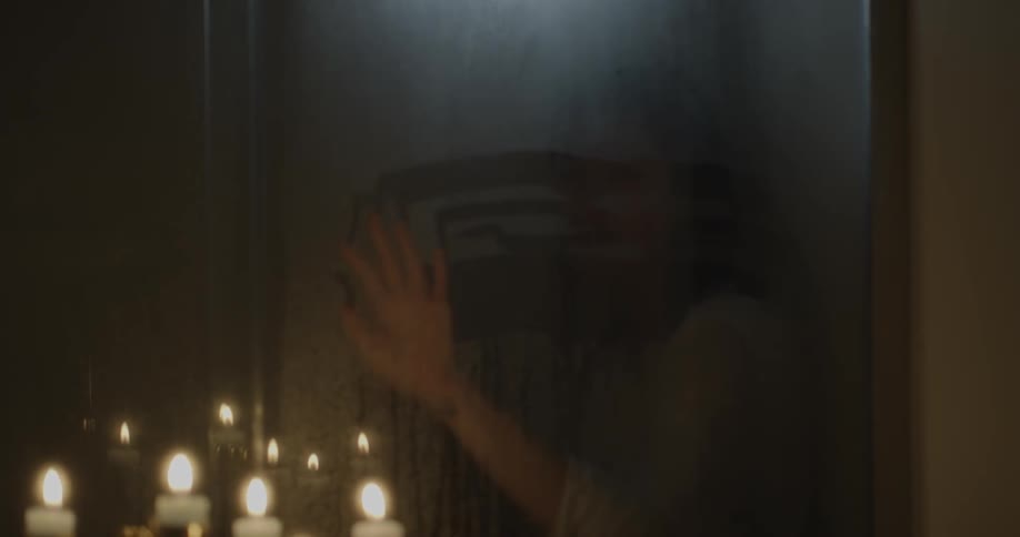 A woman wipes the moisture from the window