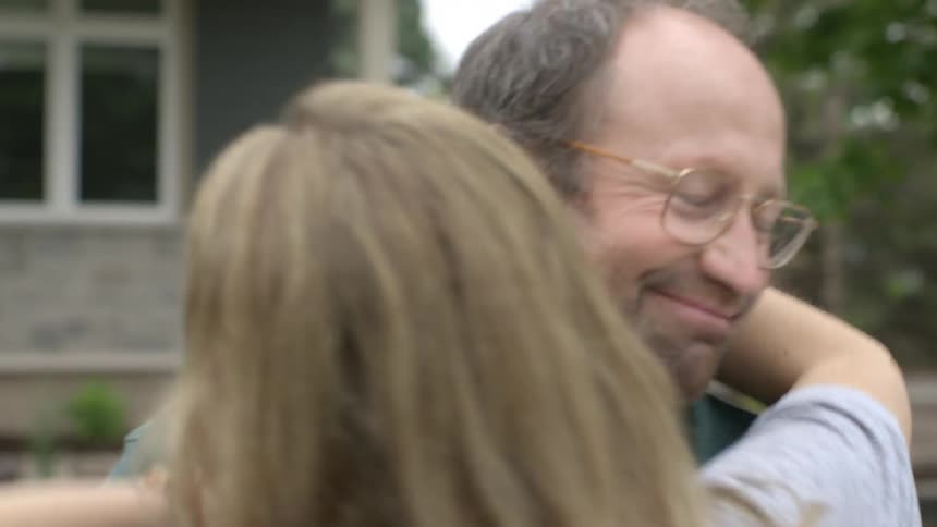 A man and woman hug outdoors