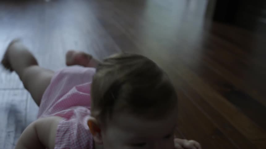 A baby is crawling across the floor