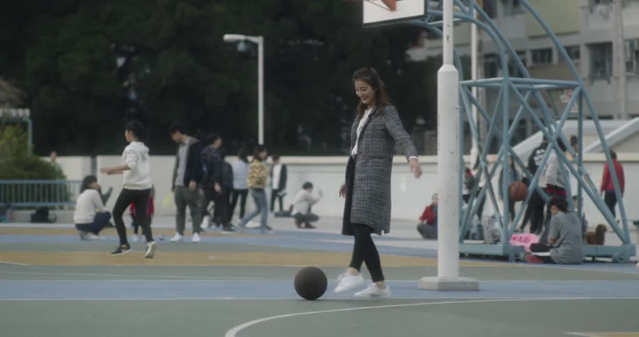 A woman kicks a basketball along the court