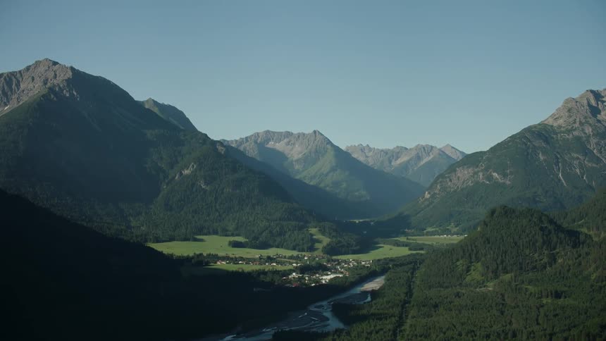 The hills and mountains are all covered with green on a sunny day