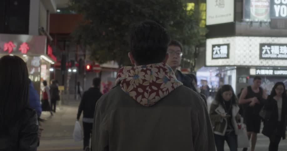 The city street is busy with people walking all along the street