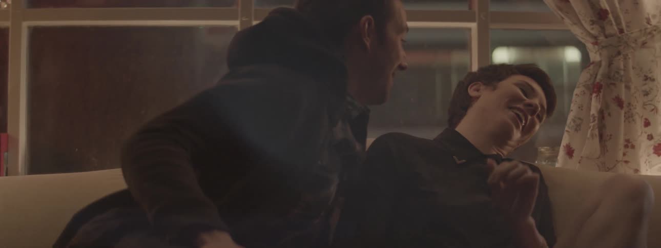 A man leans in to kiss a woman who pulls away laughing