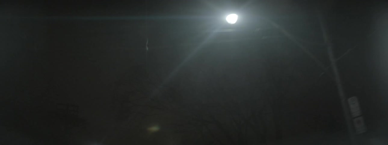 Signs line the dark road at night