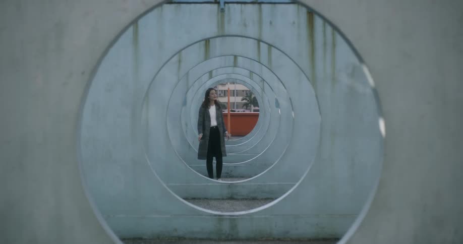 A woman is walking through circles touching each as she passes