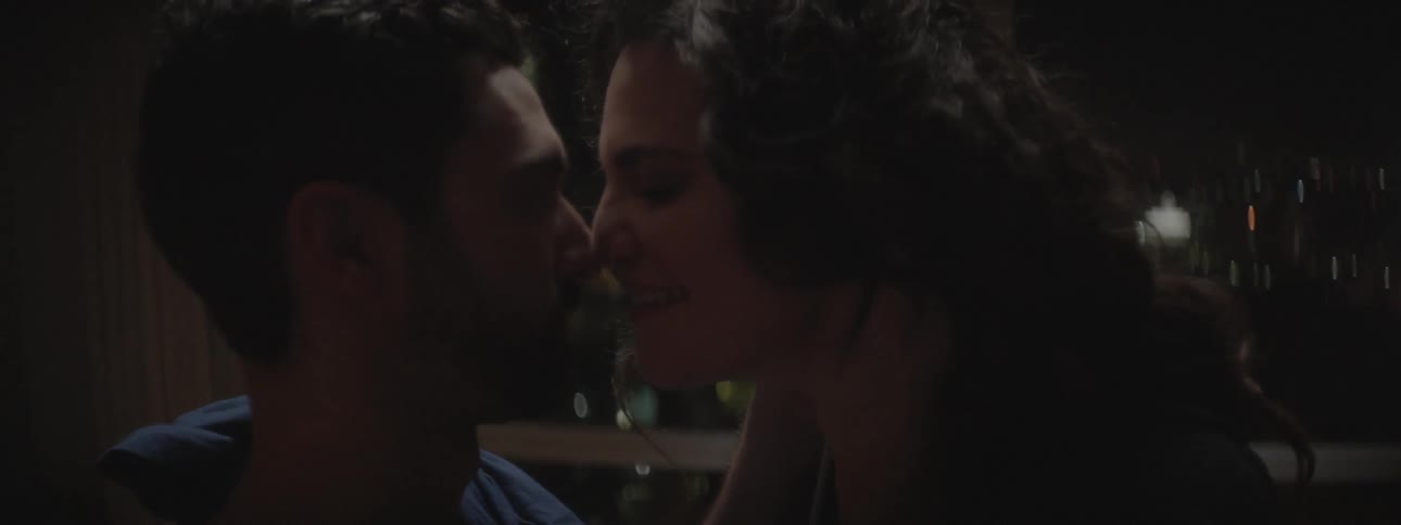 Two people are kissing in the dark together