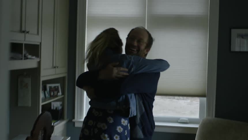 A father hugs his excited daughter