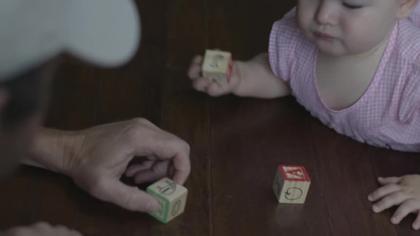 A man is playing with blocks with a baby