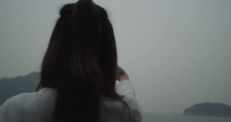 A woman is taking a selfie by the water