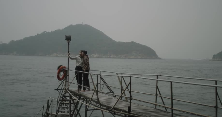 A couple takes a photo on a dock