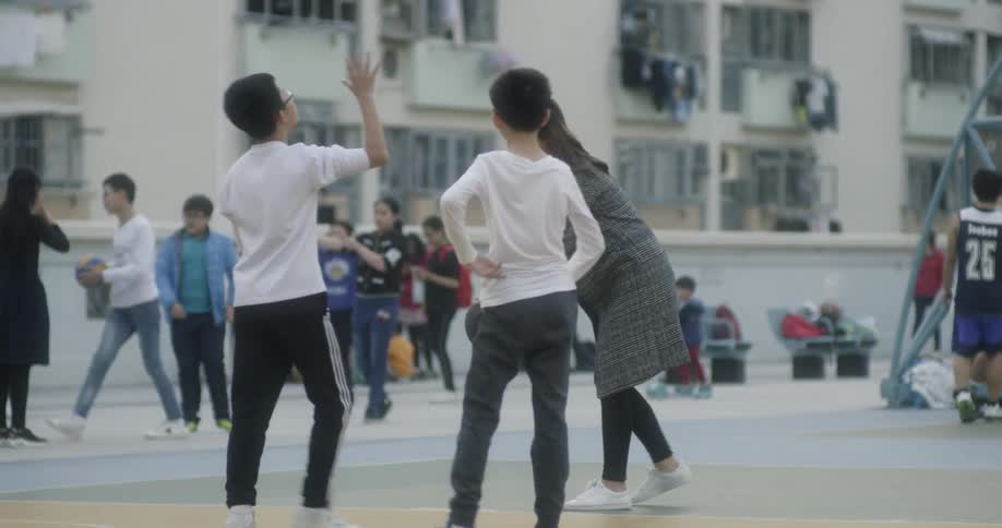 A woman dribbles a basketball and shoots while others play around her