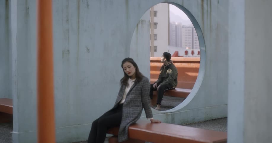 People sit on benches in a park looking at the sights