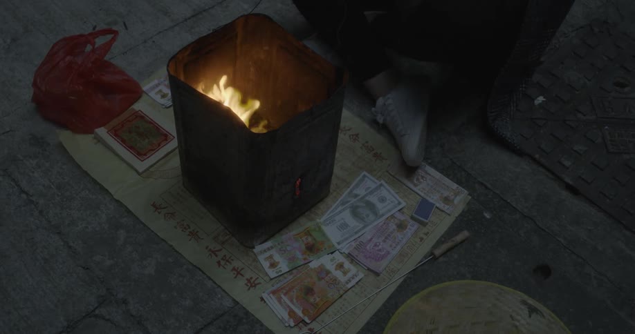Person putting money into can with burning fire